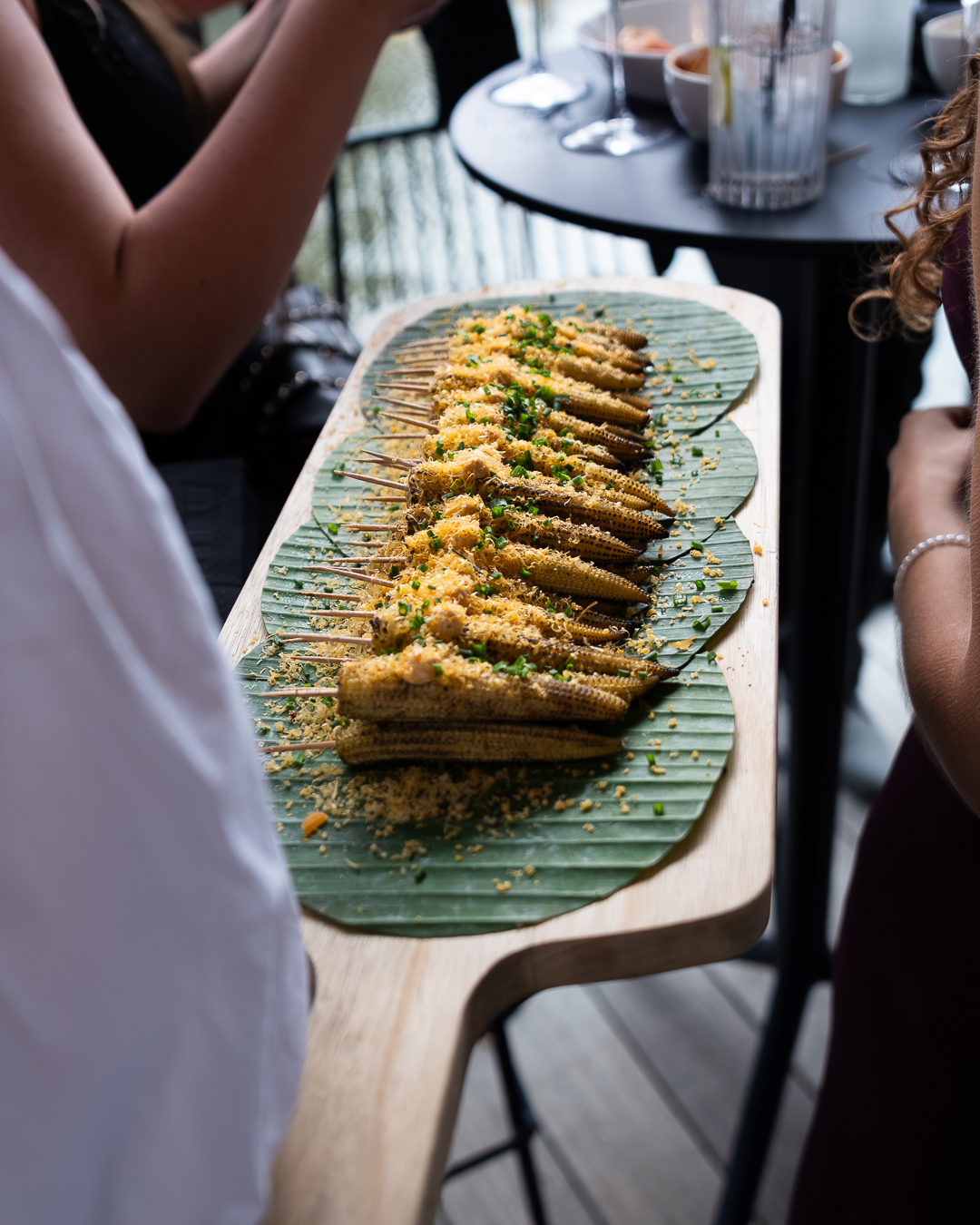 Gegrilde babymaïs aan het spies op een bananenblad