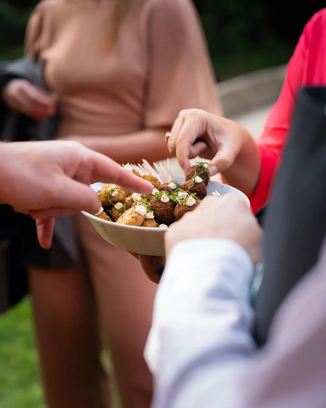 Gasten nemen hapjes van een schaal tijdens een receptie
